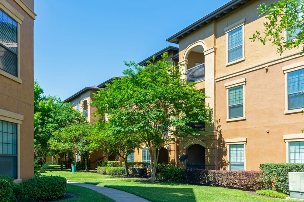 Apartments in Northwest Houston North A serene apartment complex nestled amidst lush trees and vibrant shrubs, offering apartments for rent in NW Houston North.